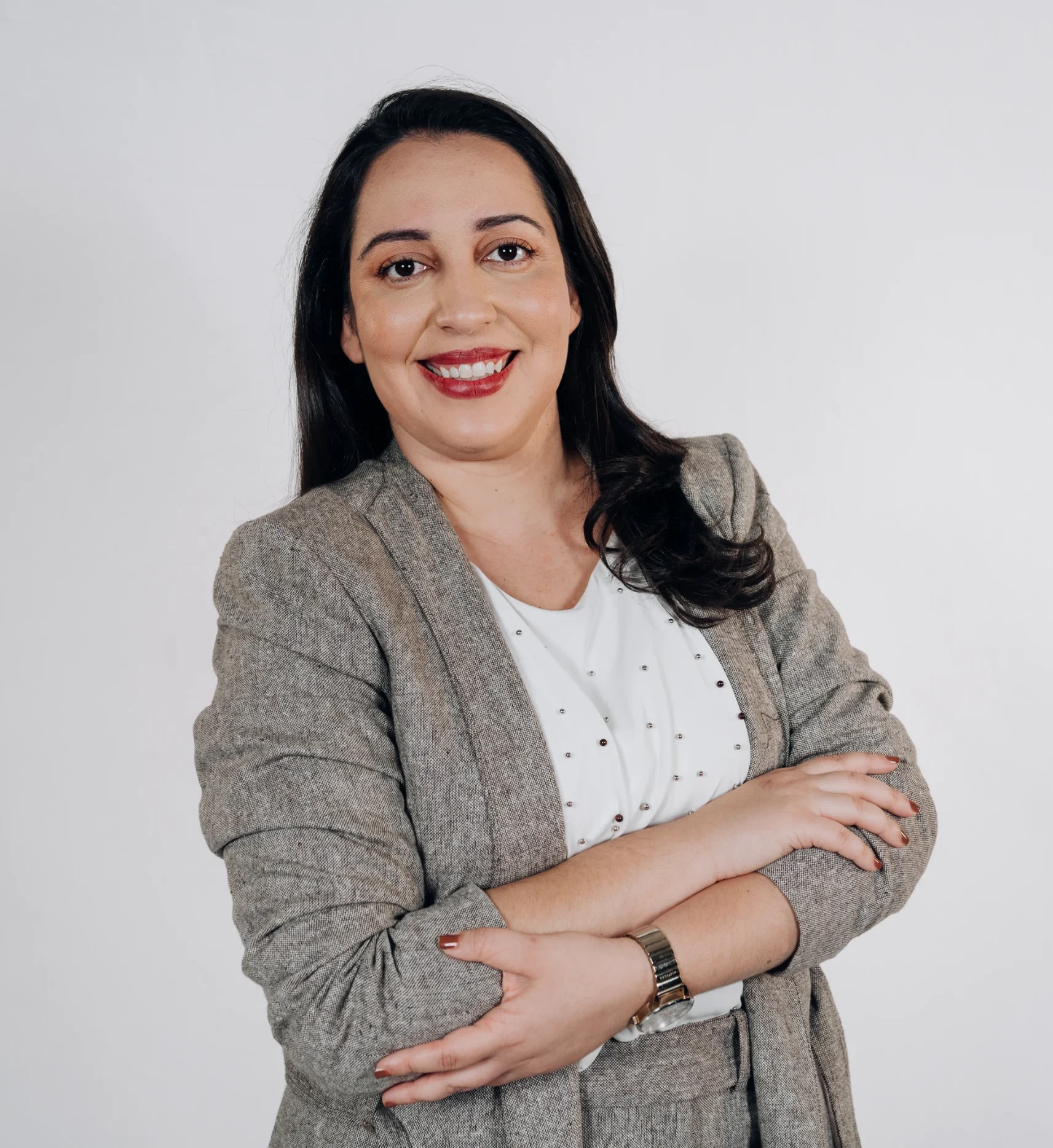 Headshot de Livia Barcelos, psicóloga clínica e fundadora do Espaço Elleve, sorrindo em fundo neutro